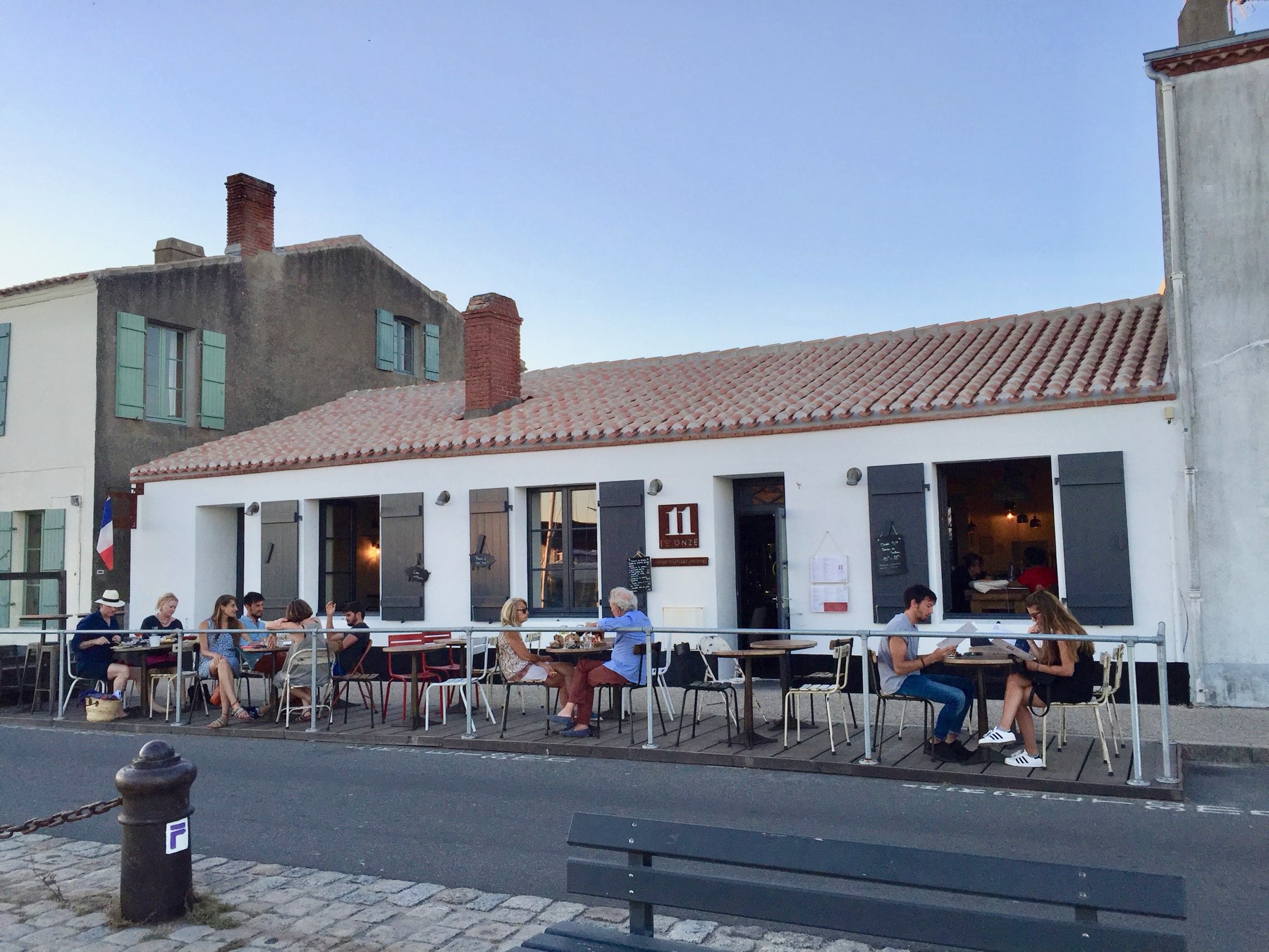 Diners outside Café Onze on the old port at dusk