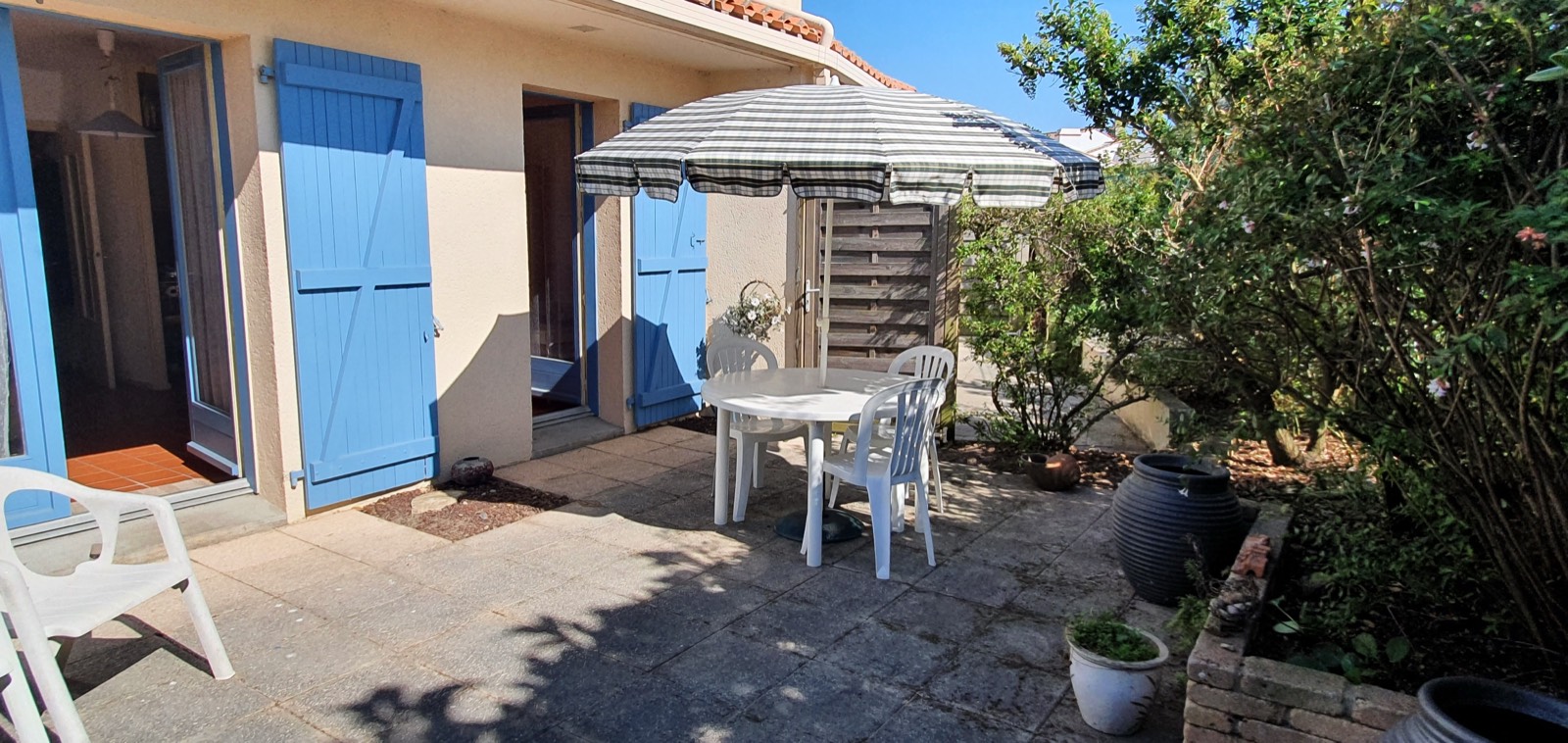 The exterior of B27 with blue shutters and a sunny terrace