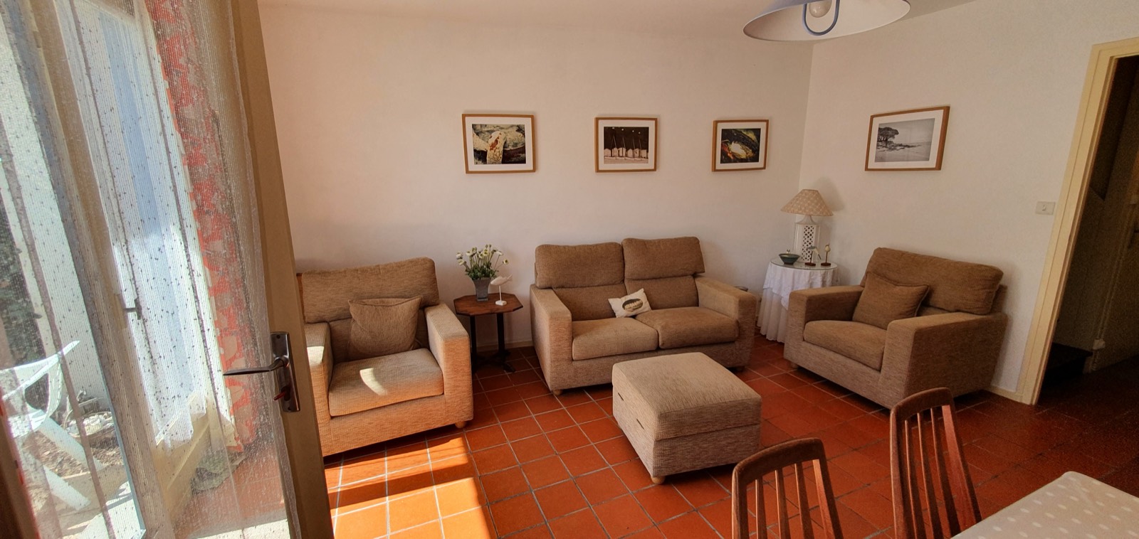 B27's lounge with sofas and armchairs on a terracotta-tiled floor, opening to the garden