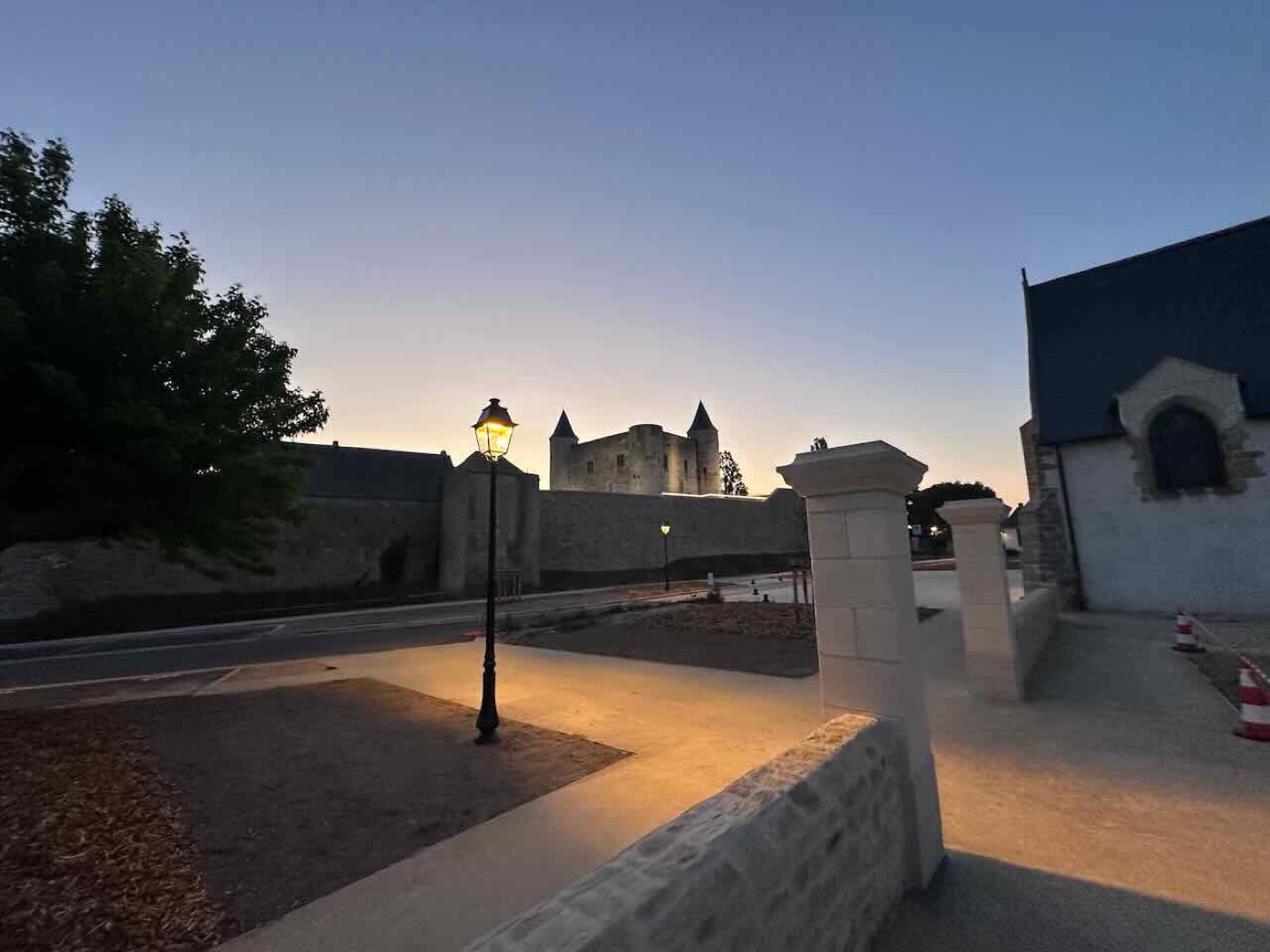 The château and church seen across the square at dusk
