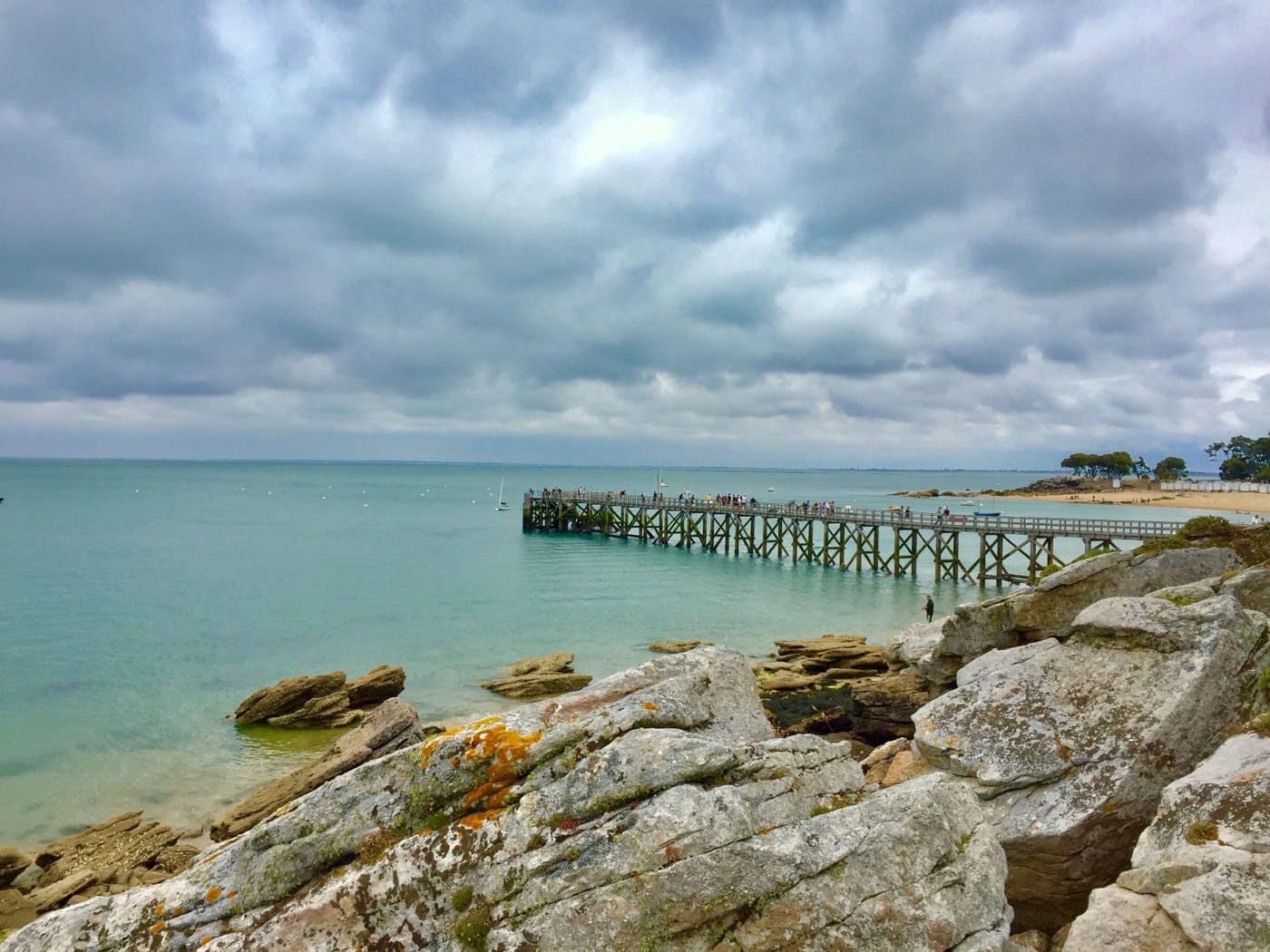 The wooden pier at Plages des Dames under a dramatic sky