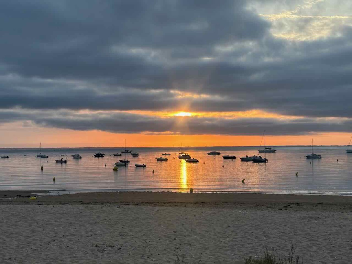 Boats moored off the beach at sunset